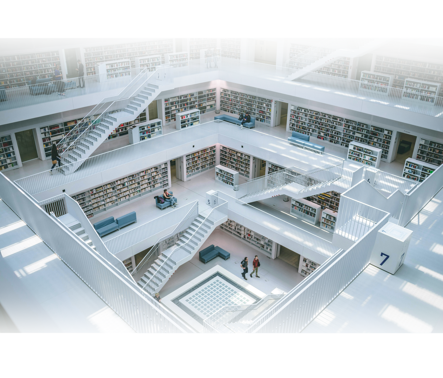 Blick in die Stadtbibliothek am Mailänder Platz, Stuttgart - mehrere Etagen und Treppen. Einge Menschen gehen durch die Gänge.